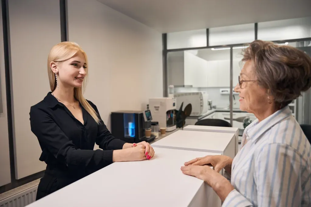 A receptionist greeting an older patient
