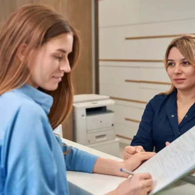 A patient reviewing documents with reception
