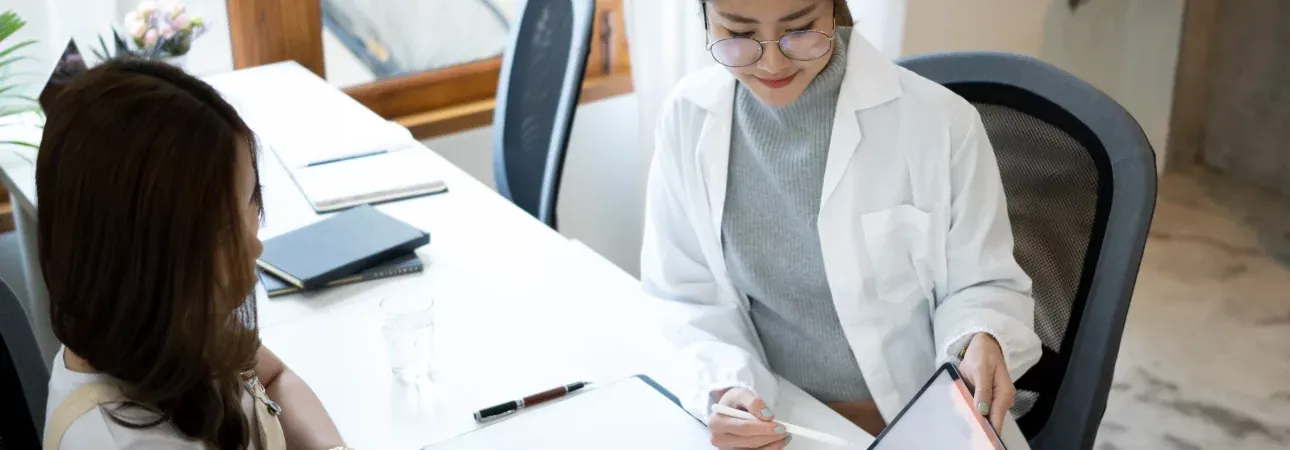 A doctor explaining health information to a patient on a tablet