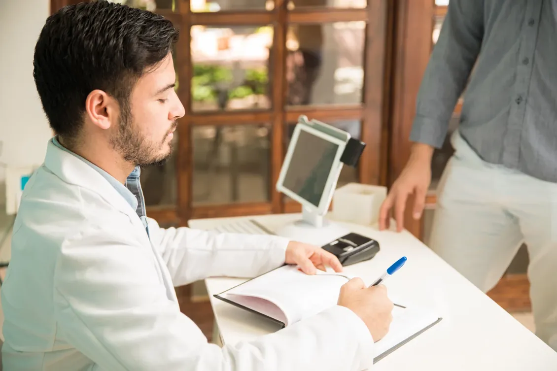 A doctor booking an appointment at his desk